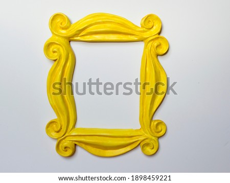 Yellow photo frame or mirror frame with a white background, to frame texts or images. Royalty-Free Stock Photo #1898459221