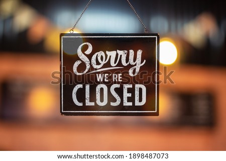 Sorry we're closed sign. grunge image hanging on a glass door. Royalty-Free Stock Photo #1898487073