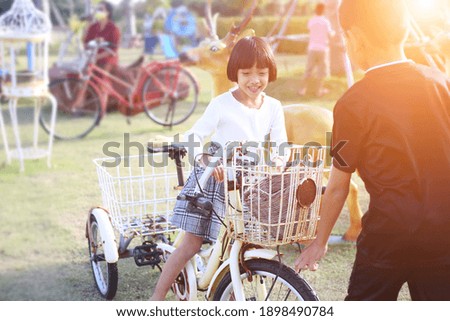 A girl riding a bicycle in the park with a blurred background