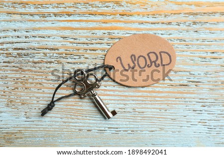 Key with tag WORD on blue wooden background, top view. Keyword concept