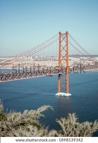 Lisbon, Portugal - March 29, 2019: panorama of the famous 25th April suspension bridge on the tage river Royalty-Free Stock Photo #1898539342