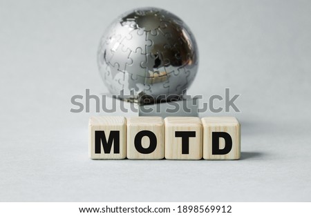 Text MOTD. Globe and wooden cubes on a gray background. The concept of world business, marketing, finance.