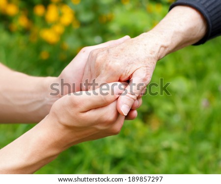 Doctor's hand holding a wrinkled elderly hand