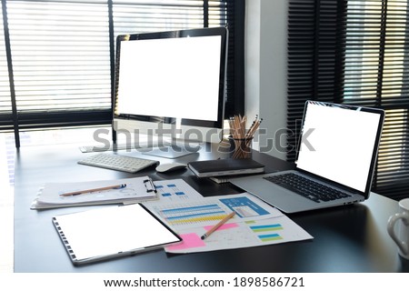 Workspace with desktop computer, office supplies,  at home or studio. Blank screen for graphics display montage.