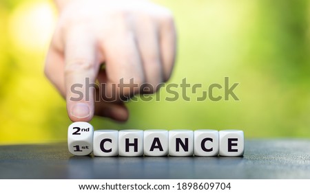 Hand turns dice and changes the expression "1st chance" to "2nd chance". Royalty-Free Stock Photo #1898609704