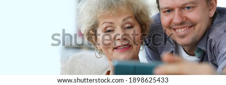 Grandma shows her page on a social network. Elderly woman shares her observations online