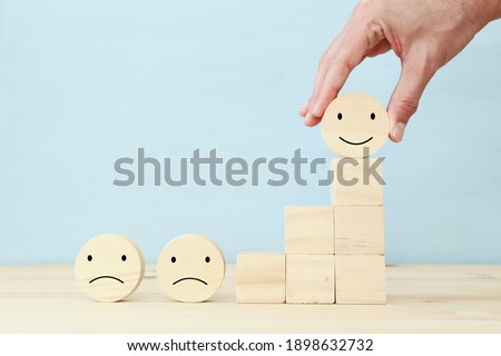 Concept image of satisfaction level. wooden cubes with emotions