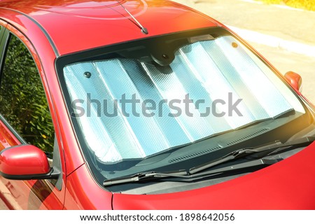 Sun shade under windshield in car, closeup. Heat protection Royalty-Free Stock Photo #1898642056