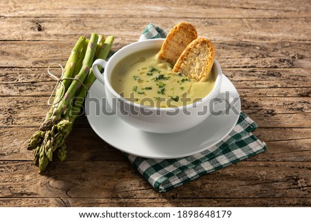 Fresh green asparagus soup in bowl on wooden table Royalty-Free Stock Photo #1898648179