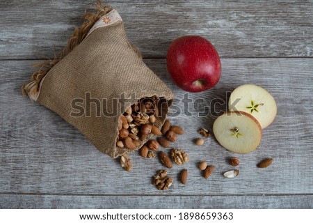 nuts almonds hazelnuts in a bag and apples on the table