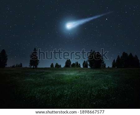 Night scene with a comet, asteroid, meteorite flying to Earth. Night landscape. Elements of this image furnished by NASA. 