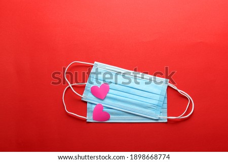 Tri-layer protection mask for clinical use with pink hearts on a red background