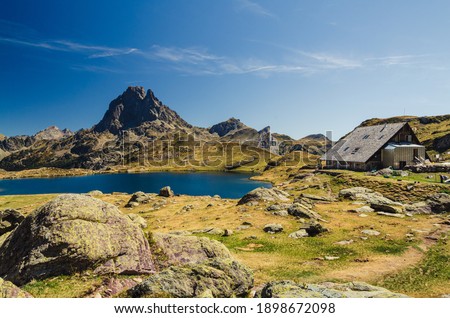 Ayous refuge with the lake and the summit of Pic du midi d'Ossau