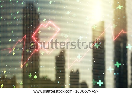 Double exposure of abstract virtual heart rate hologram on modern skyscrapers background. Healthcare technolody concept