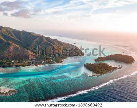 Paradise - Aerial shots of the  Sea, Mountains, and Reefs in Mo'orea, French Polynesia during Sunset  Royalty-Free Stock Photo #1898680492