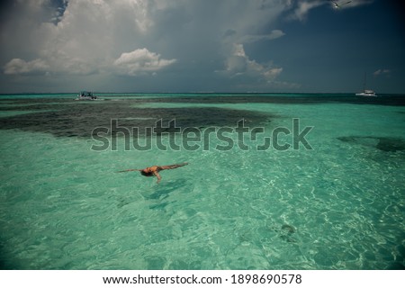 Young woman in the sea. Amazing caribbean sea. Super clean water. Beautifull island Isla Mujeres, Mexico.