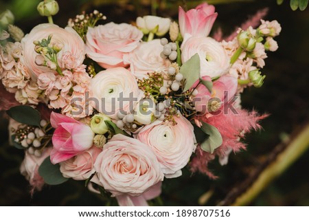 Beautiful modern bridal bouquet of colorful fresh flowers and greenery with silk ribbons. Classic wedding traditional accessory.