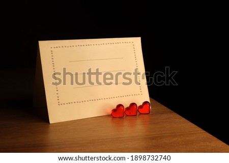 valentines day background. card with a red heart and white blank with the space for text on a wooden background