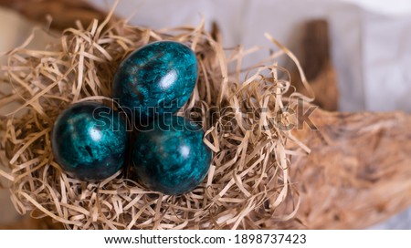 Eggs dark tidewater green tones. Easter festive background with colored eggs, decorations. Postcard for the holiday of Easter.
