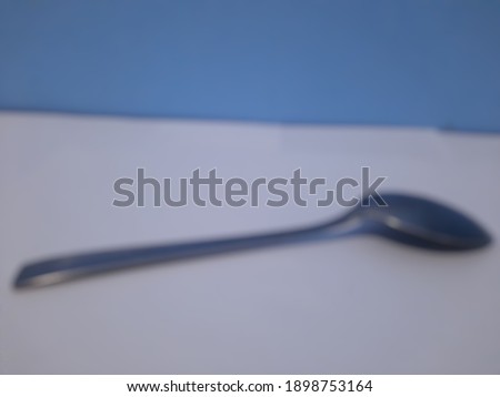 Blurred spoon with a blue background