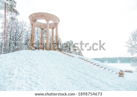 Women in white sitting near gorgeous Temple of Fame - granite rotunda in winter