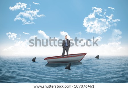 Thinking businessman against sharks circling small boat in the ocean