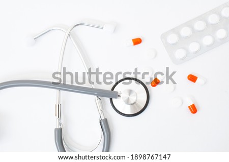 stethoscope, red heart sheet of paper for notes on a white background on the table