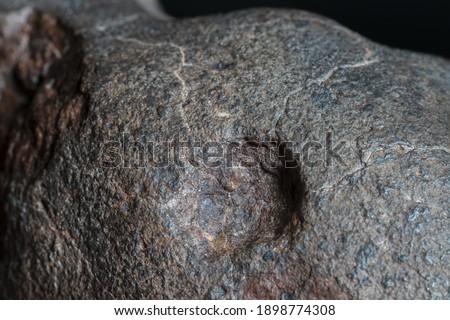 Macro photo of the fusion crust from a Chondrite Meteorite, piece of rock formed in outer space in the early stages of Solar System as asteroids. This meteorite comes from an asteroid fall at Atacama