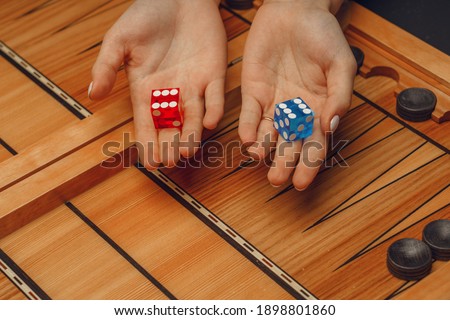 wooden backgammon and girl's hands with bones for the game