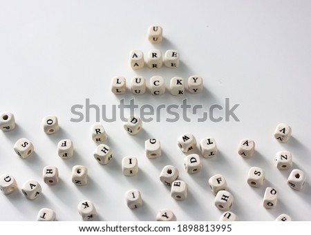 You are lucky words written on wood blocks, white table background, black and white letters on wooden blocks. Business success and motivation for action. High quality photo