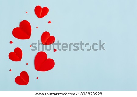 Valentine's Day background February 14th. Blank greeting card mock-up scene, confetti, red hearts of paper on pastel blue background. Valentines day concept. Flat lay, top view, copy space