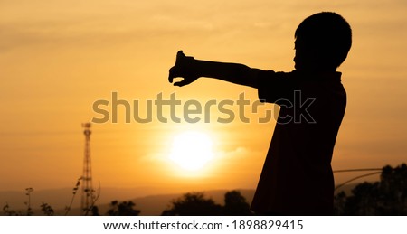 Shadow children exercise on morning of golden sky background 