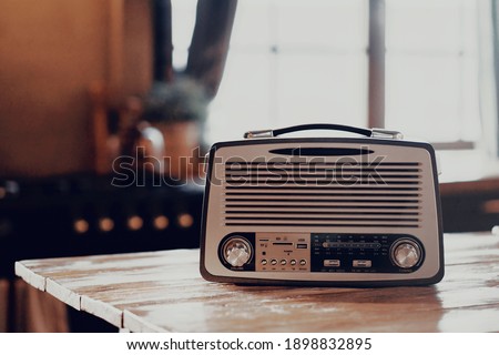 an old vintage radio receiver sits on a wooden table. stylish old kitchen morning in the village and daylight from the window. copy space Royalty-Free Stock Photo #1898832895