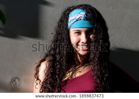 Lifestyle Scene, Latin American girl smiles between shadows and sunset lights