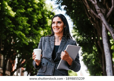 Portrait of latin business woman walking in the street of a colonial city in latin america