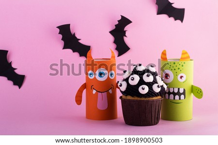 paper ghosts with a mystical cupcake for Halloween. Creative Halloween background with sweets