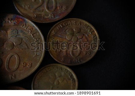 Old Malaysia coins on black background. Malaysia money. There are 1,5,10,20,and 50 cents. Concept for saving, banking, finance, investment, trading and planning. 