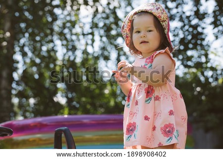 Little girl playing on the playground in the yard