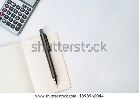flatlay topview of working table including pen , note , calculator and sticky note isolated 