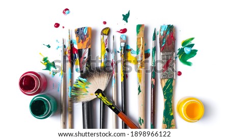 Top view of tool for artist, different size used brushes with colorful paint for art and drawing on white background Royalty-Free Stock Photo #1898966122