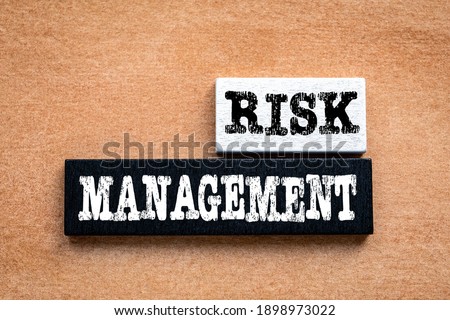 RISK MANAGEMENT. Business concept. Black and white wooden block on an orange .