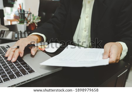 Business men use computers to look at financial data, marketing, sales, growth and research business documents.Work from home.