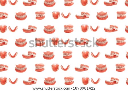 Set of dentures on a white background. Full removable plastic denture of the jaws. Isolate on white background acrylic prosthesis of human jaws. Upper and lower jaws with fake teeth. Jaw in all angles Royalty-Free Stock Photo #1898981422