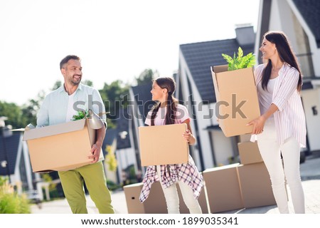 Photo of happy positive family mommy daddy kid childhood smile enjoy purchase buy new apartment home hold boxes relocation urban