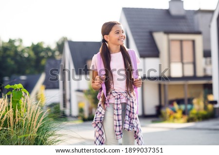 Photo portrait of dreamy schoolgirl looking to side wearing pink rucksack outdoors