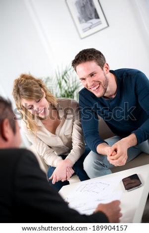 cheerful young couple with salesman at home
