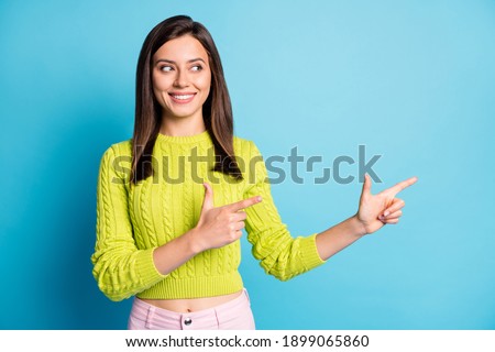 Photo of young attractive smile girl advert advice choice recommend point fingers empty space isolated over blue color background