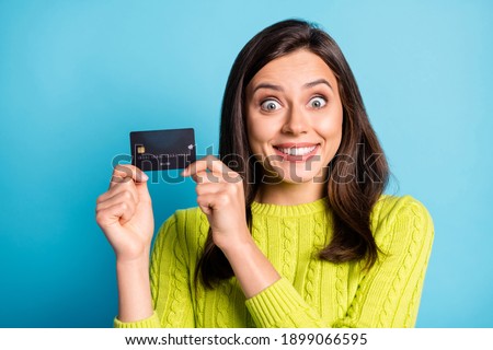 Photo of young excited happy positive smile girl hold bank card income salary isolated over blue color background