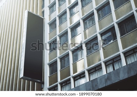 Black rectangular signboard on the wall of a modern business center, mockup