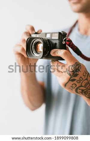 Photographer with tattoos shooting with a film camera